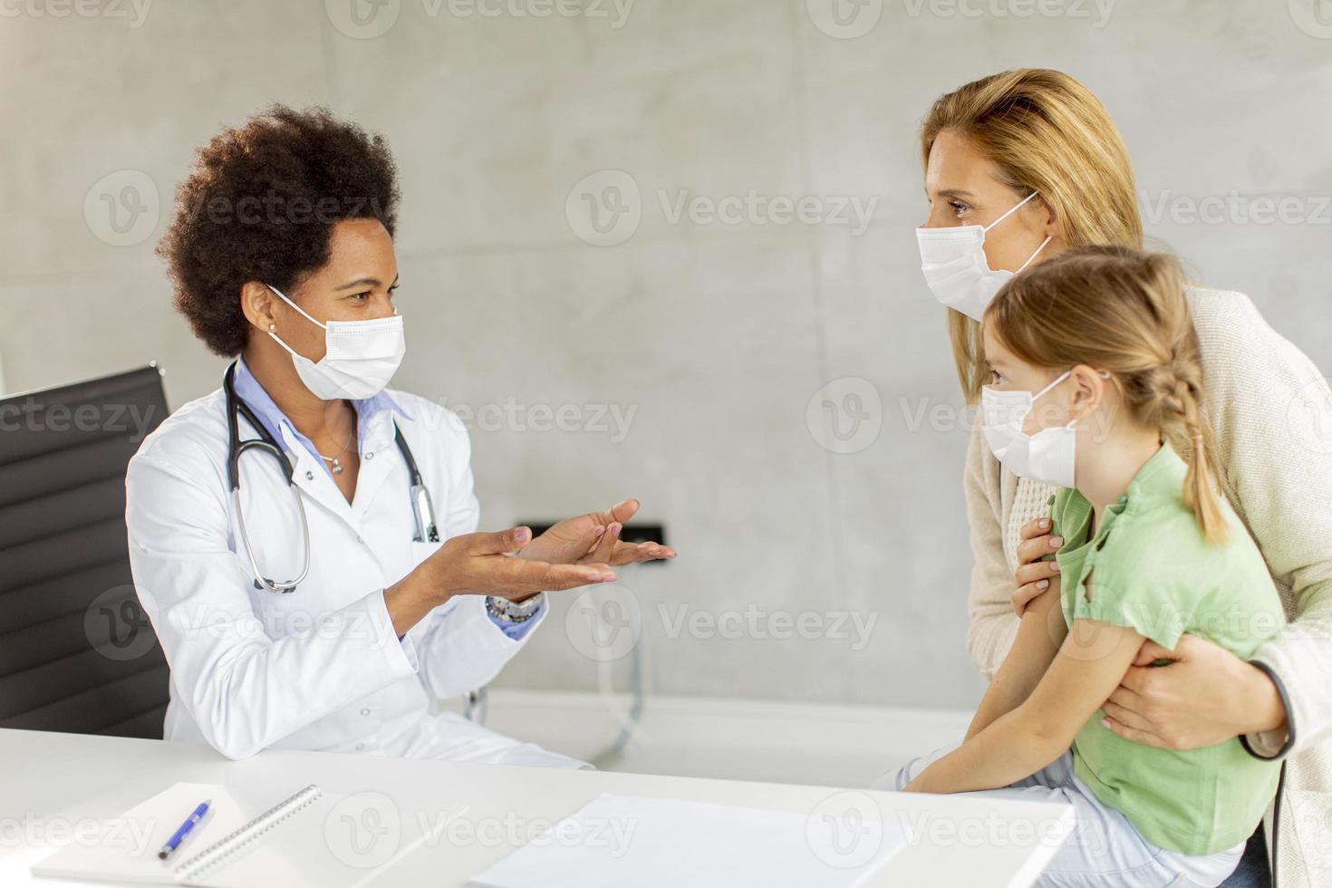 pediatra conversando com mãe e paciente foto