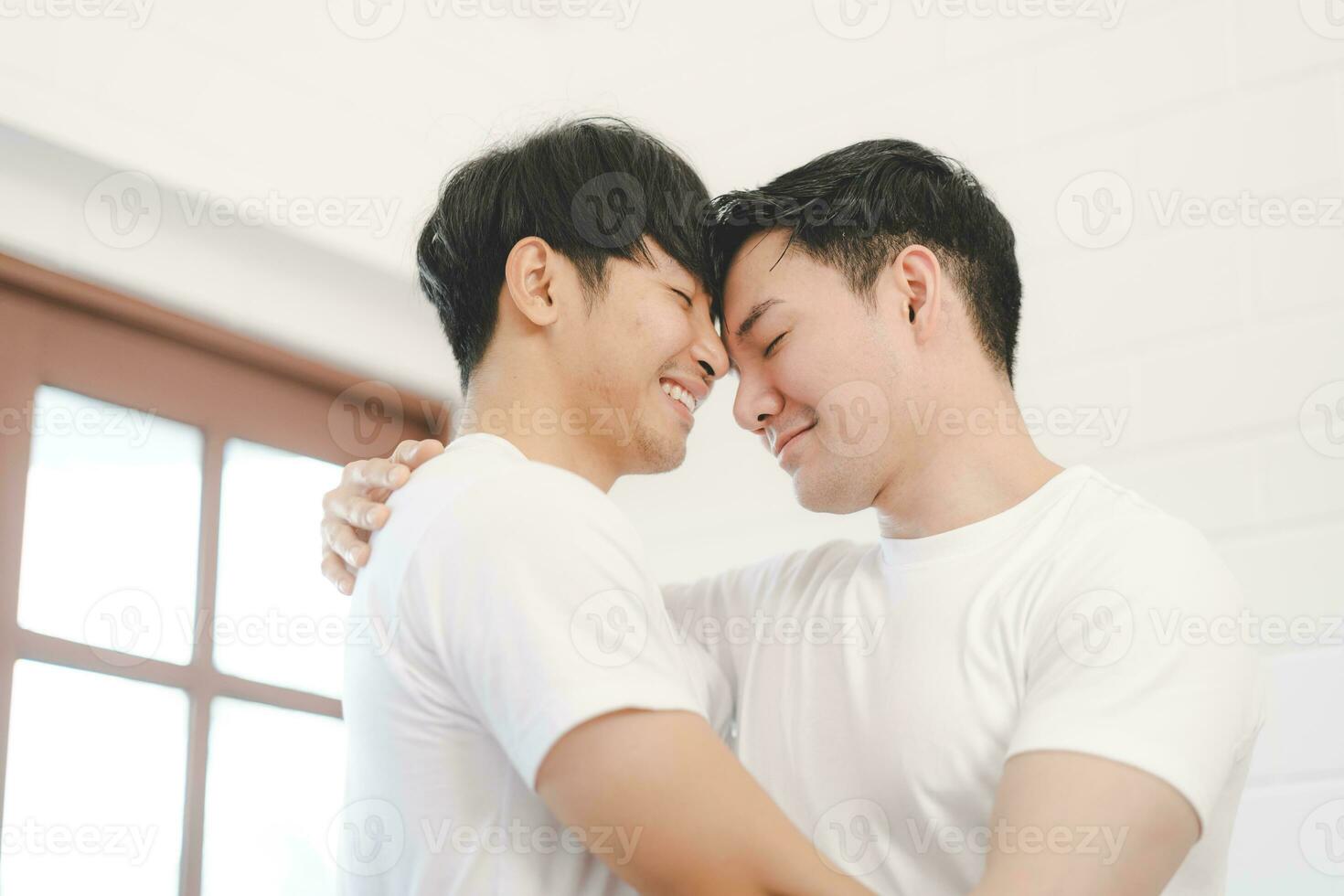 feliz ásia gay casal abraço juntos em sofá. ásia lgbt casal abraçando juntos às lar. diversidade do lgbt relacionamentos. uma gay casal conceito. lgbt multi relação. foto