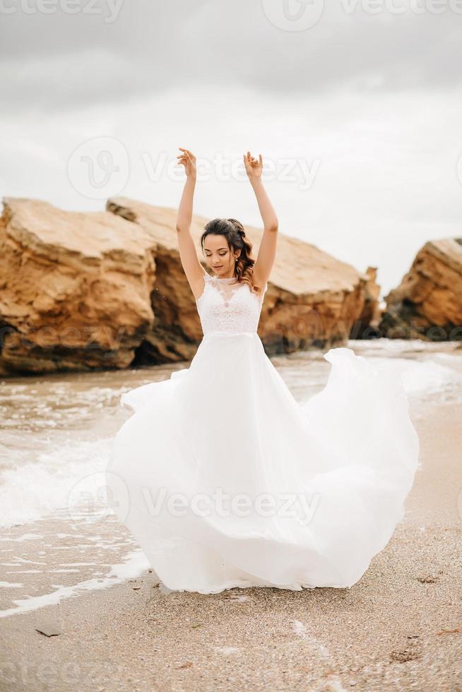 jovem casal noivo com a noiva em uma praia arenosa foto