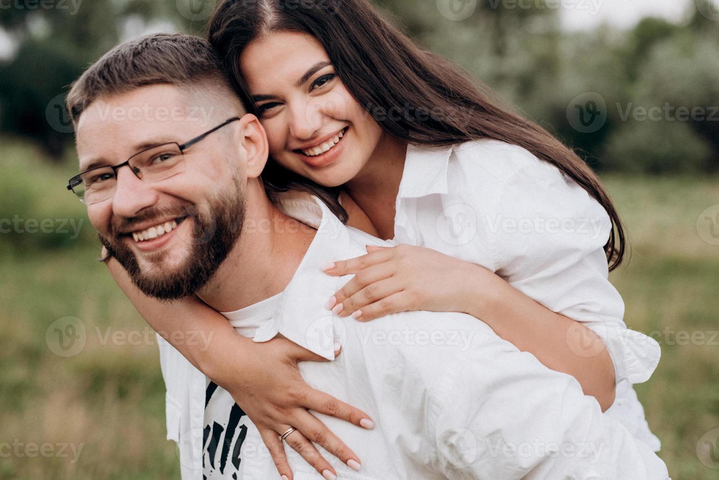 jovem casal apaixonado um cara com barba e uma garota com cabelos escuros em roupas leves foto