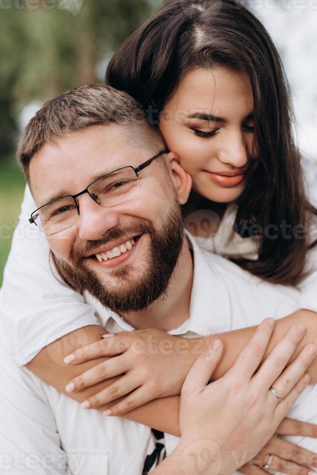 jovem casal apaixonado um cara com barba e uma garota com cabelos escuros em roupas leves foto
