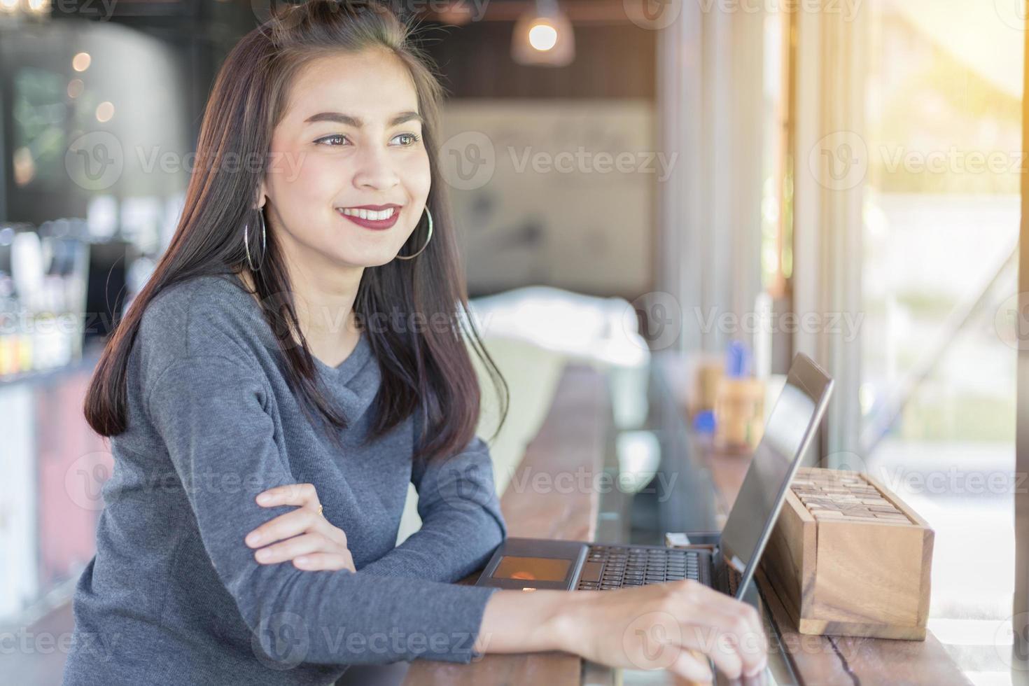 mulher sorrindo enquanto usa o laptop foto