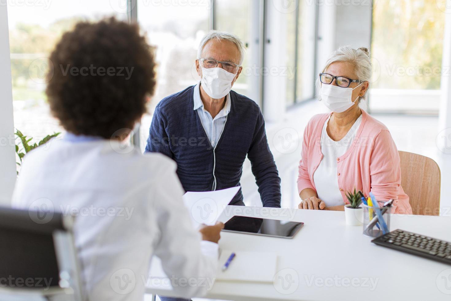 médico falando com casal maduro foto