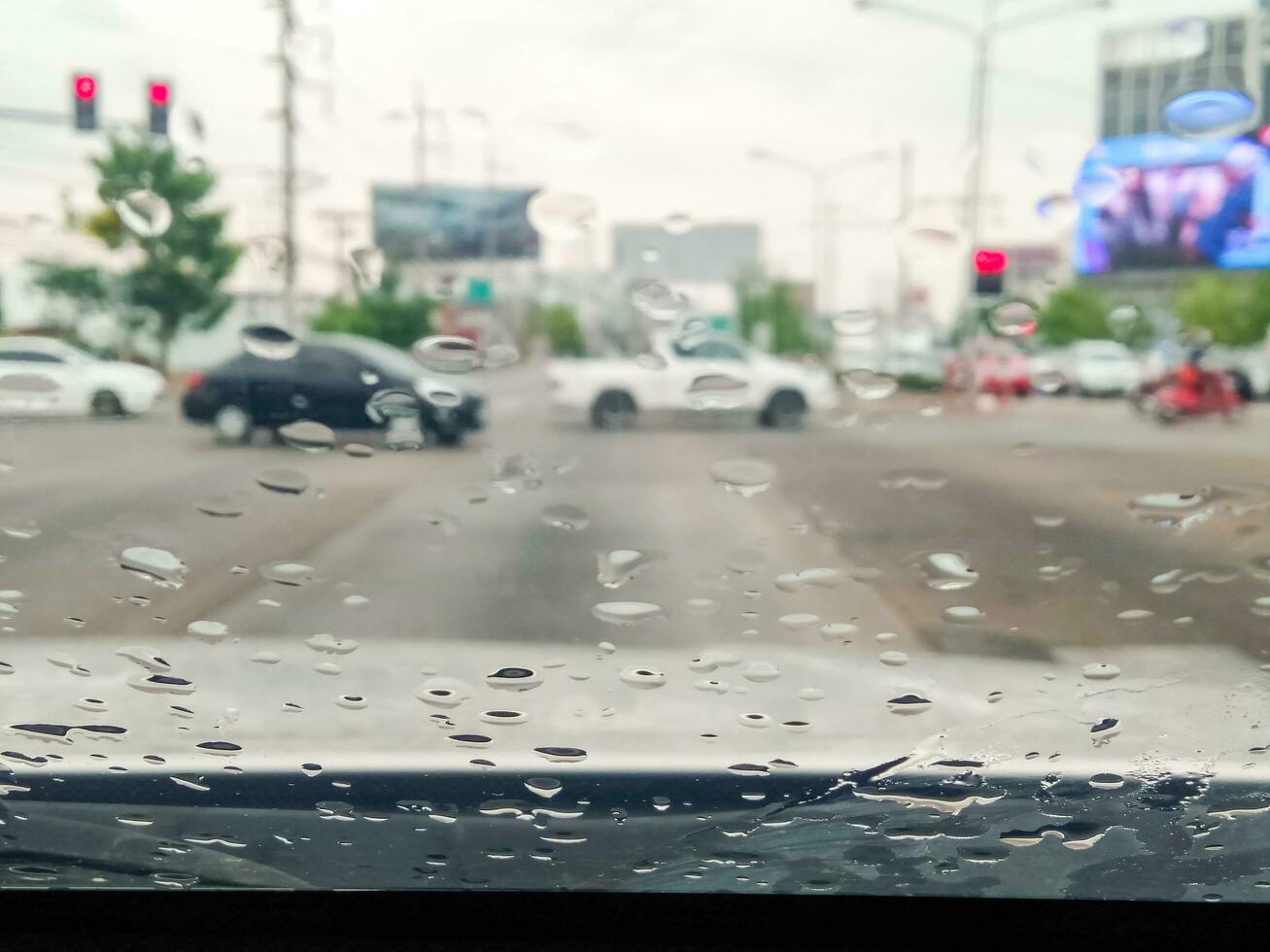 chuva gotas em a parabrisa tráfego em uma chuvoso dia foto