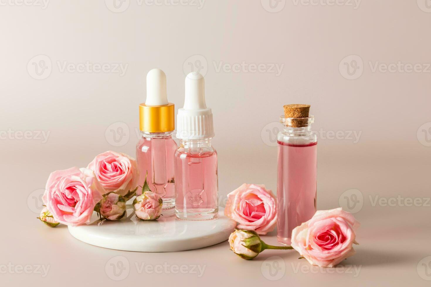uma conjunto do cosméticos dentro vários garrafas Sediada em a extrair do rosa pétalas em pastel fundo. facial pele Cuidado. natural cosméticos. foto