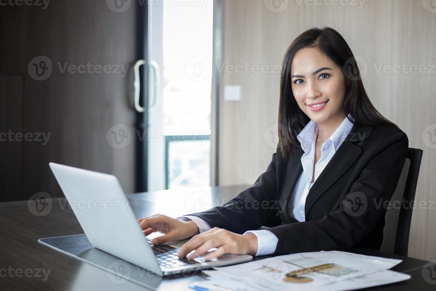 empresária asiática usando um laptop em um escritório foto