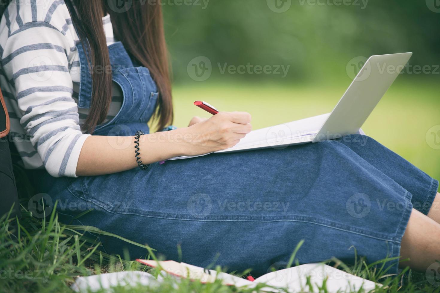 menina fazendo diário no parque foto