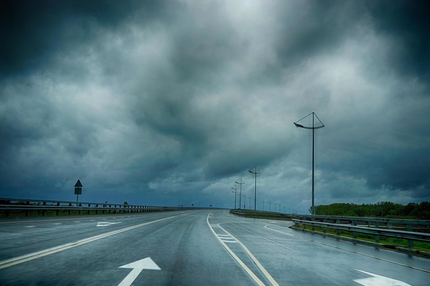 sinalizações de estradas molhadas sob um céu escuro e tempestuoso na região de Kaliningrado foto