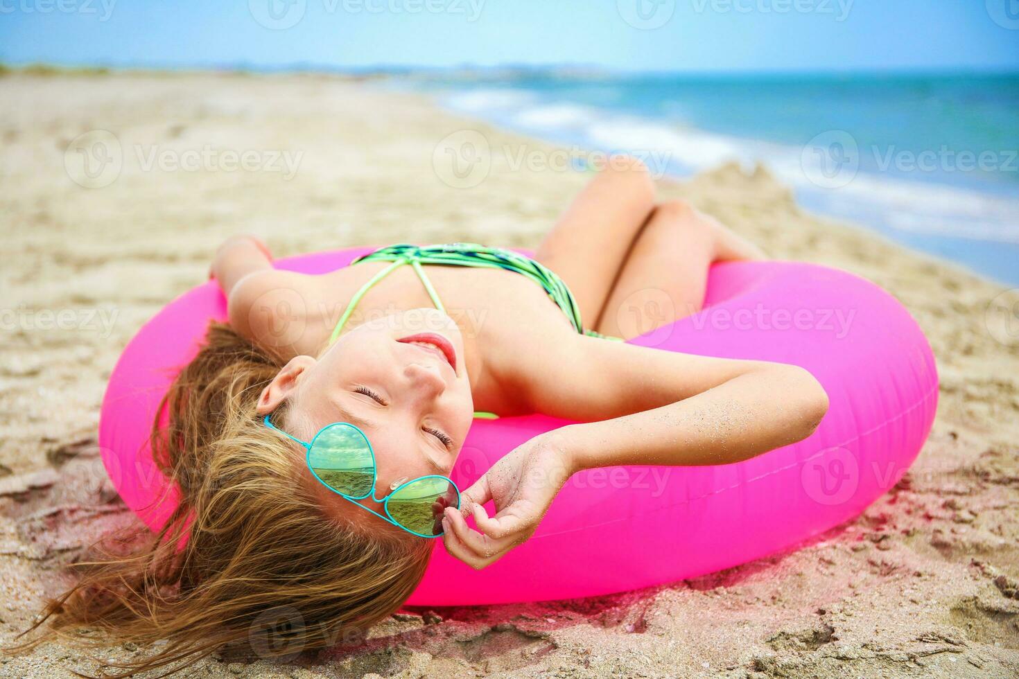 feliz menina banhos de sol em de praia. foto