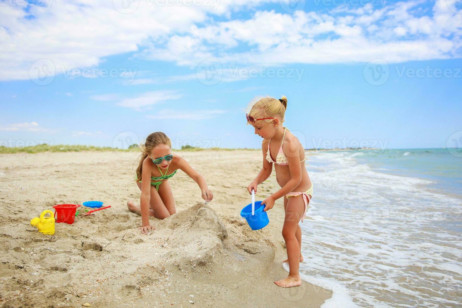 crianças jogar com areia em de praia. foto