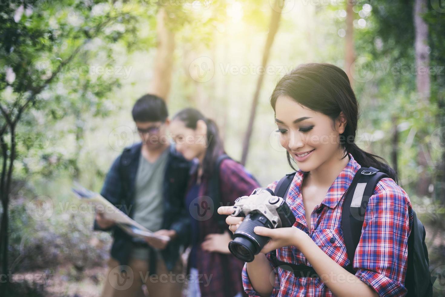 grupo de jovens amigos caminhando na floresta foto