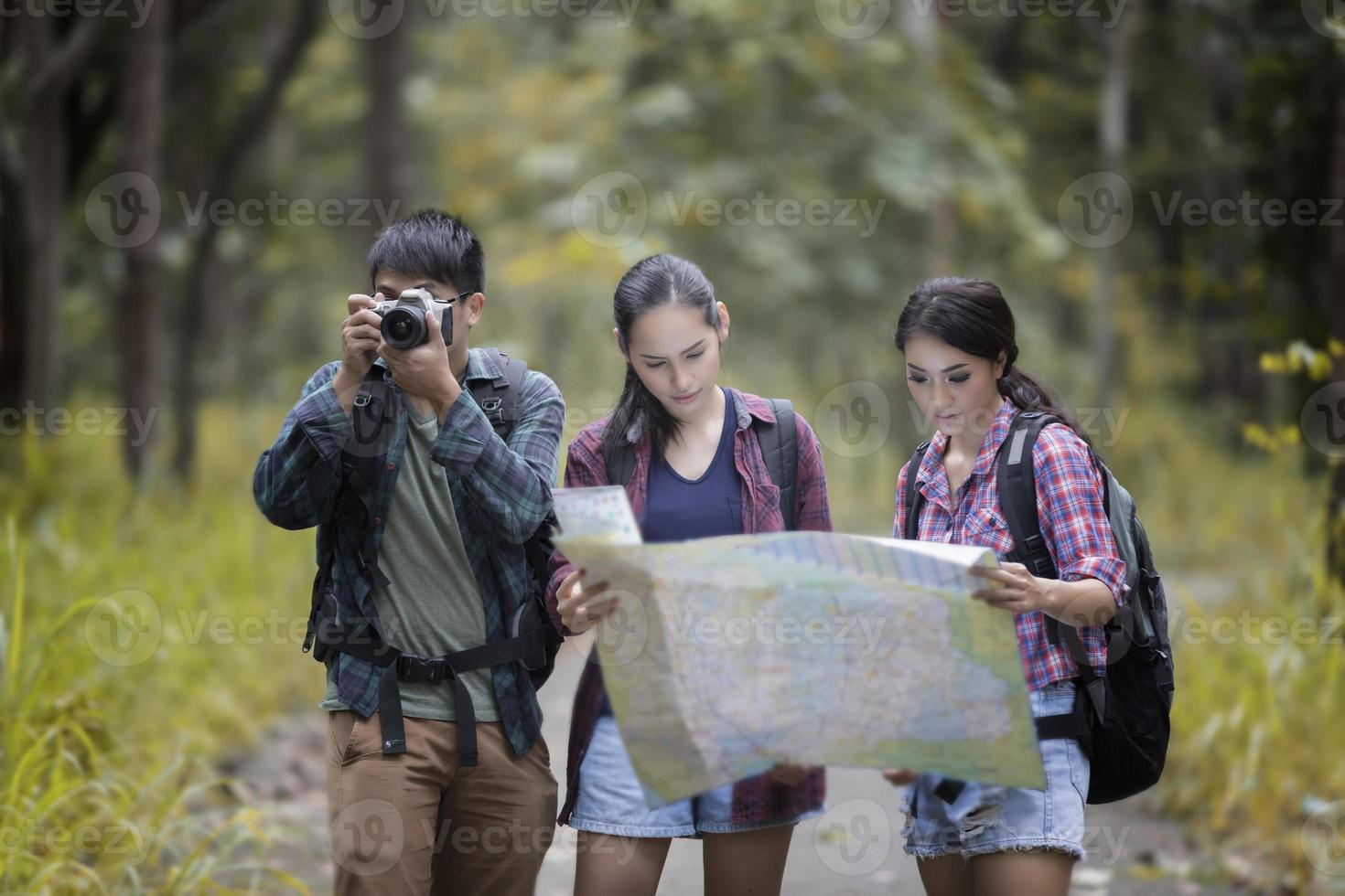 grupo de jovens amigos caminhando na floresta foto