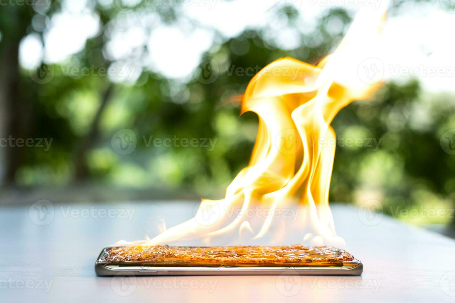 a tela do smartphone está rachada e pegando fogo com um fundo desfocado foto