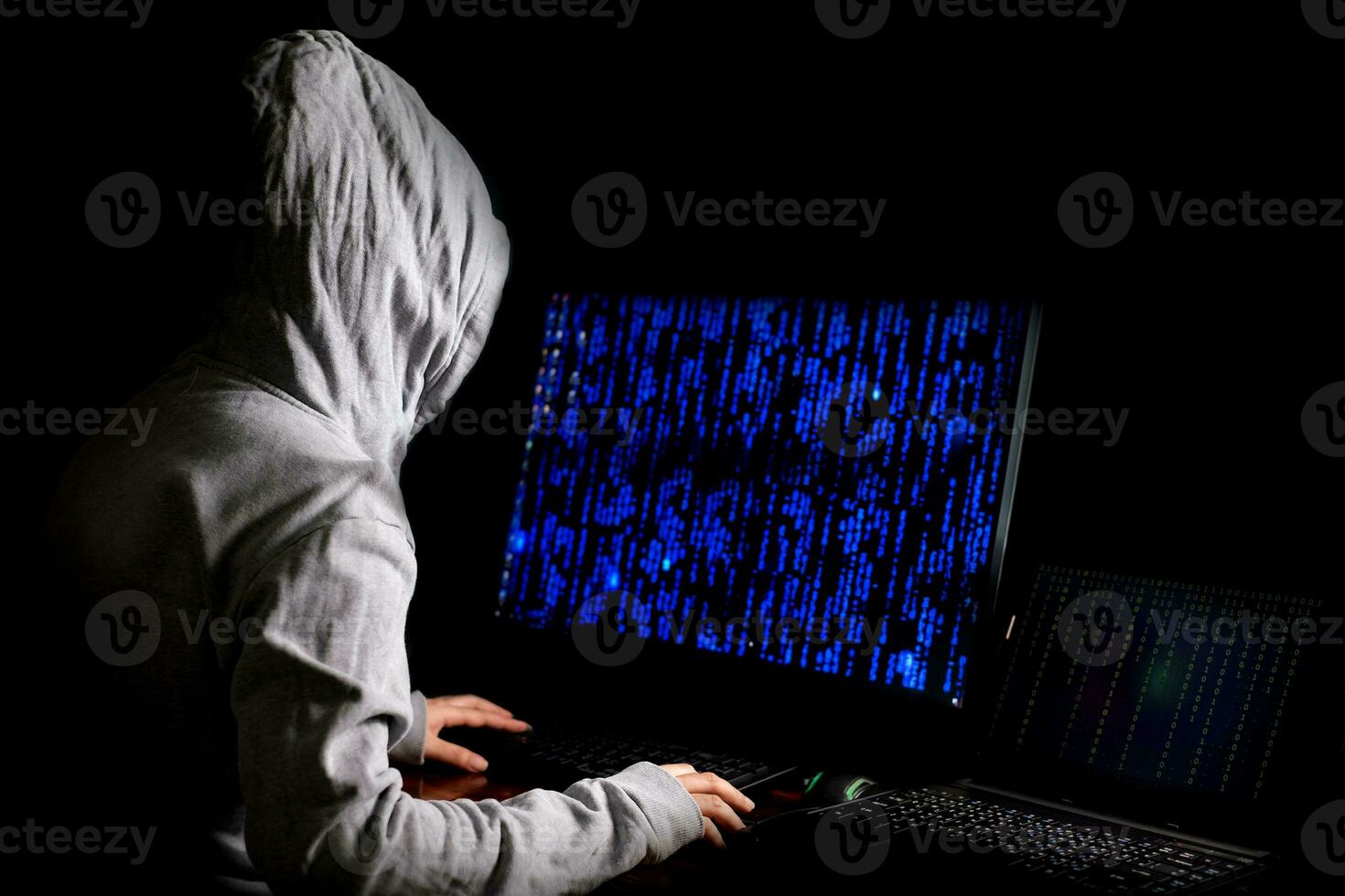 mulheres hackers invadem servidores de dados do governo e infectam seu sistema com um vírus em seu esconderijo, atmosfera azul escuro, senhora encapuzada usando laptop com fundo de código binário, conceito de malware foto