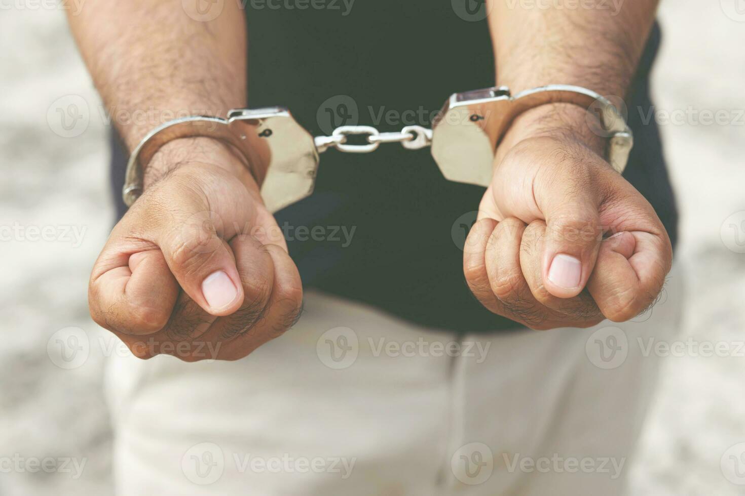 prisioneiro masculino Criminoso em pé dentro algemas com mãos atrás voltar. bandeira cópia de espaço. foto