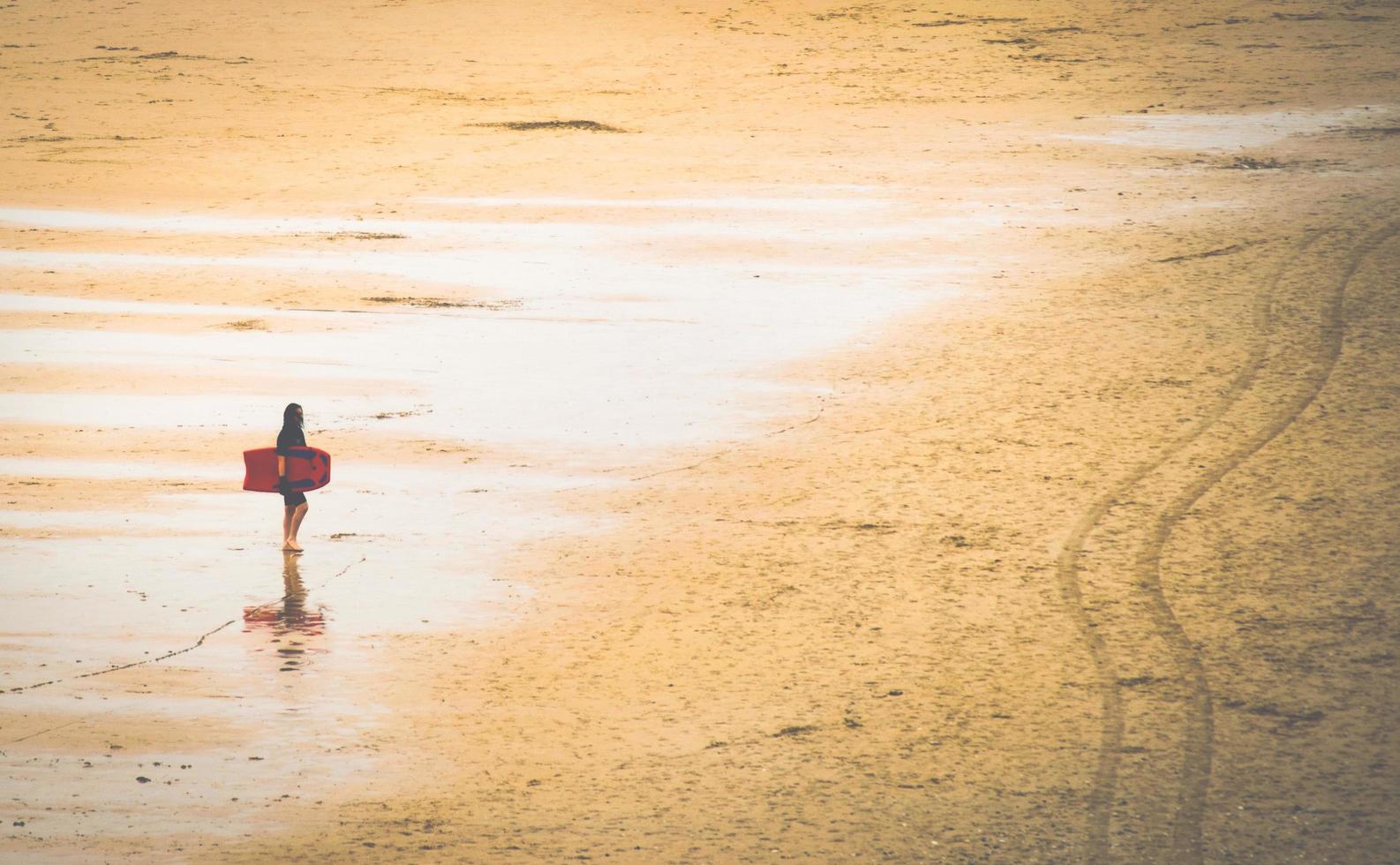 mulher na praia com prancha de surf foto