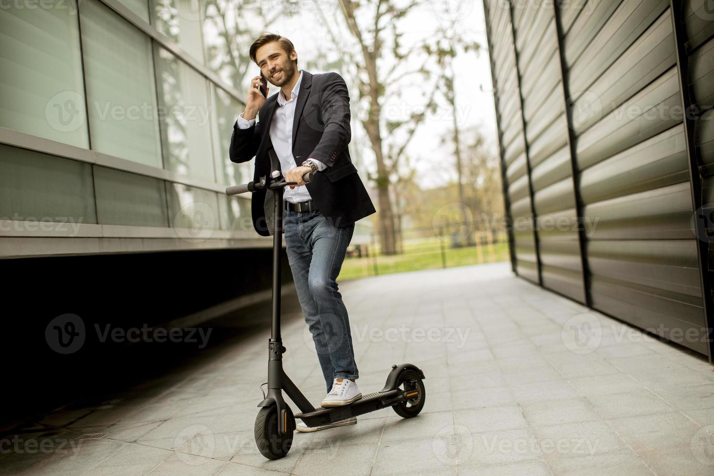 empresário no telefone enquanto está em uma scooter foto