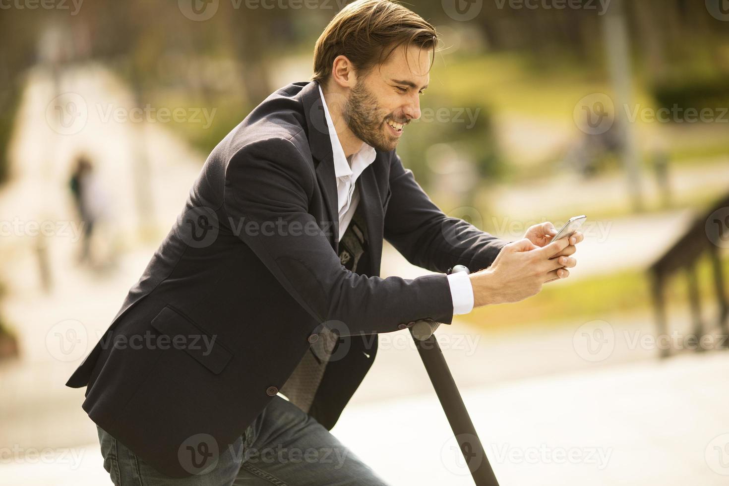 close-up de um homem enviando uma mensagem de texto em uma scooter foto