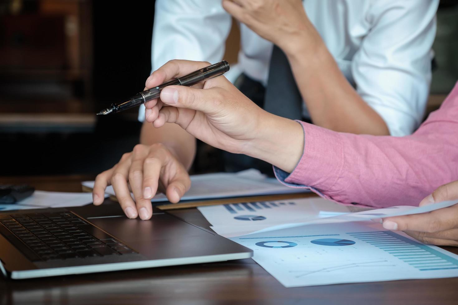 discussões de pesquisa econômica, equipe de negócios analisando tabelas de renda e gráficos para planejar o conceito de marketing com o uso de laptop e caneta para análise. foto