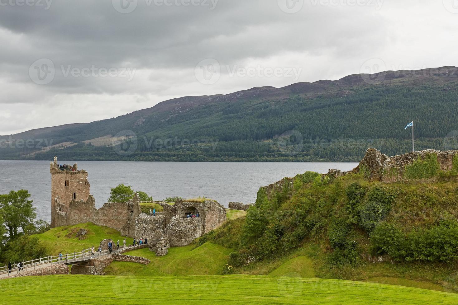 pessoas aproveitando a visita no castelo urquhart na costa do lago ness na Escócia foto
