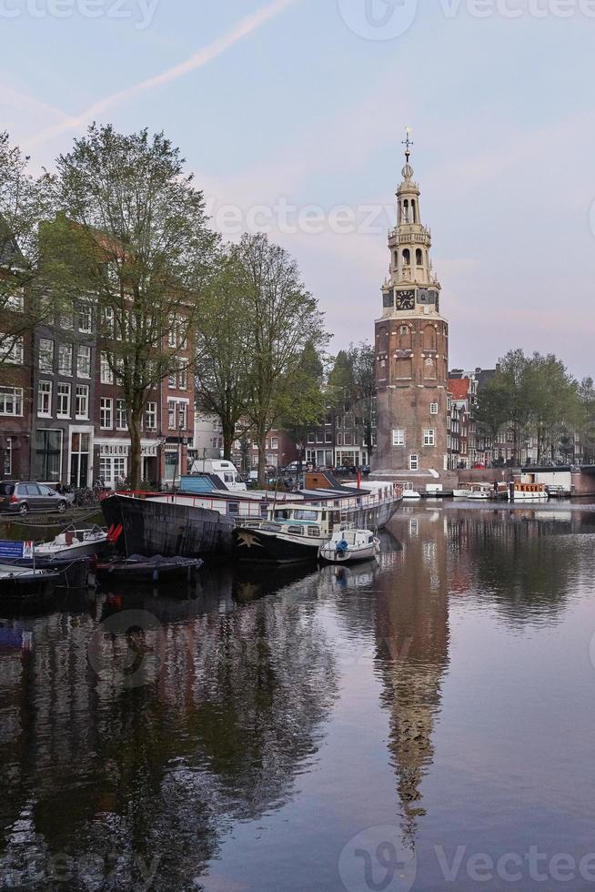 uma das igrejas de amsterdã na holanda, com uma paisagem urbana ao longo do canal durante a manhã foto