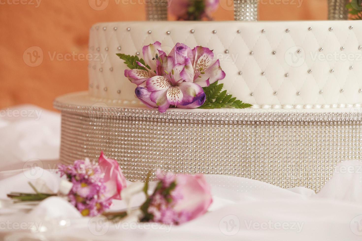 bolo de casamento branco decorado com flores e conjunto de cortadores foto