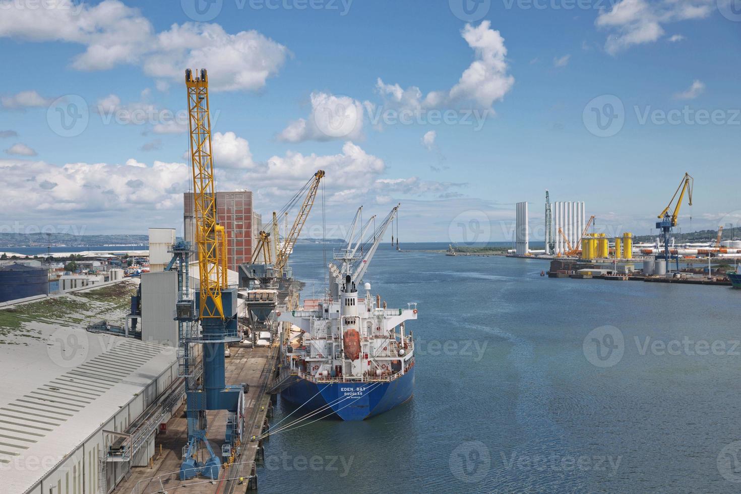 grandes guindastes industriais carregando navio de contêiner em belfast port na irlanda foto