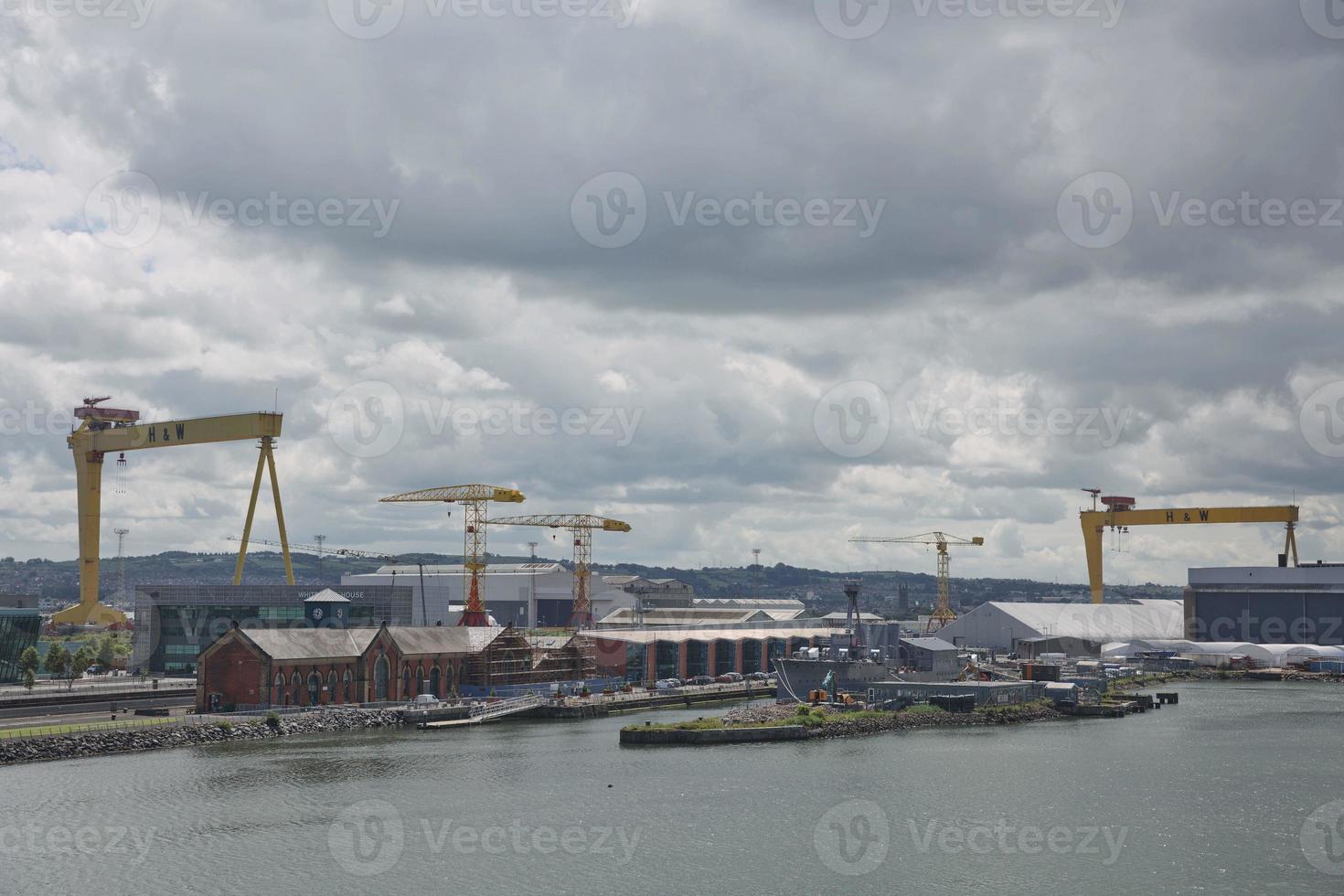 grandes guindastes industriais carregando navio de contêiner em belfast port na irlanda foto