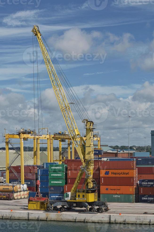 grandes guindastes industriais carregando contêineres no porto de dublin, na irlanda foto