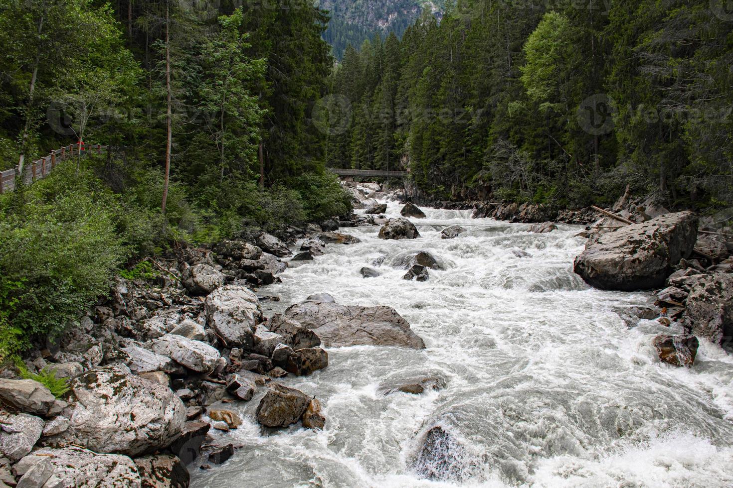 ponte de madeira cruza o rio Oetztaler nos Alpes austríacos foto