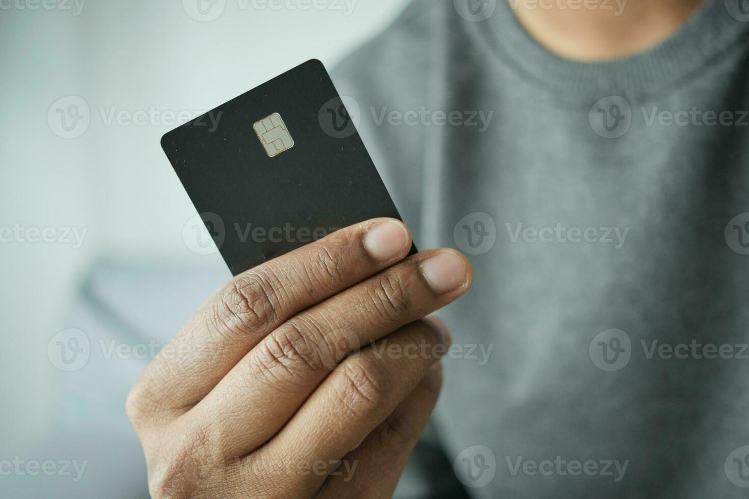 homem em vestido casual mostrando cartão de crédito foto