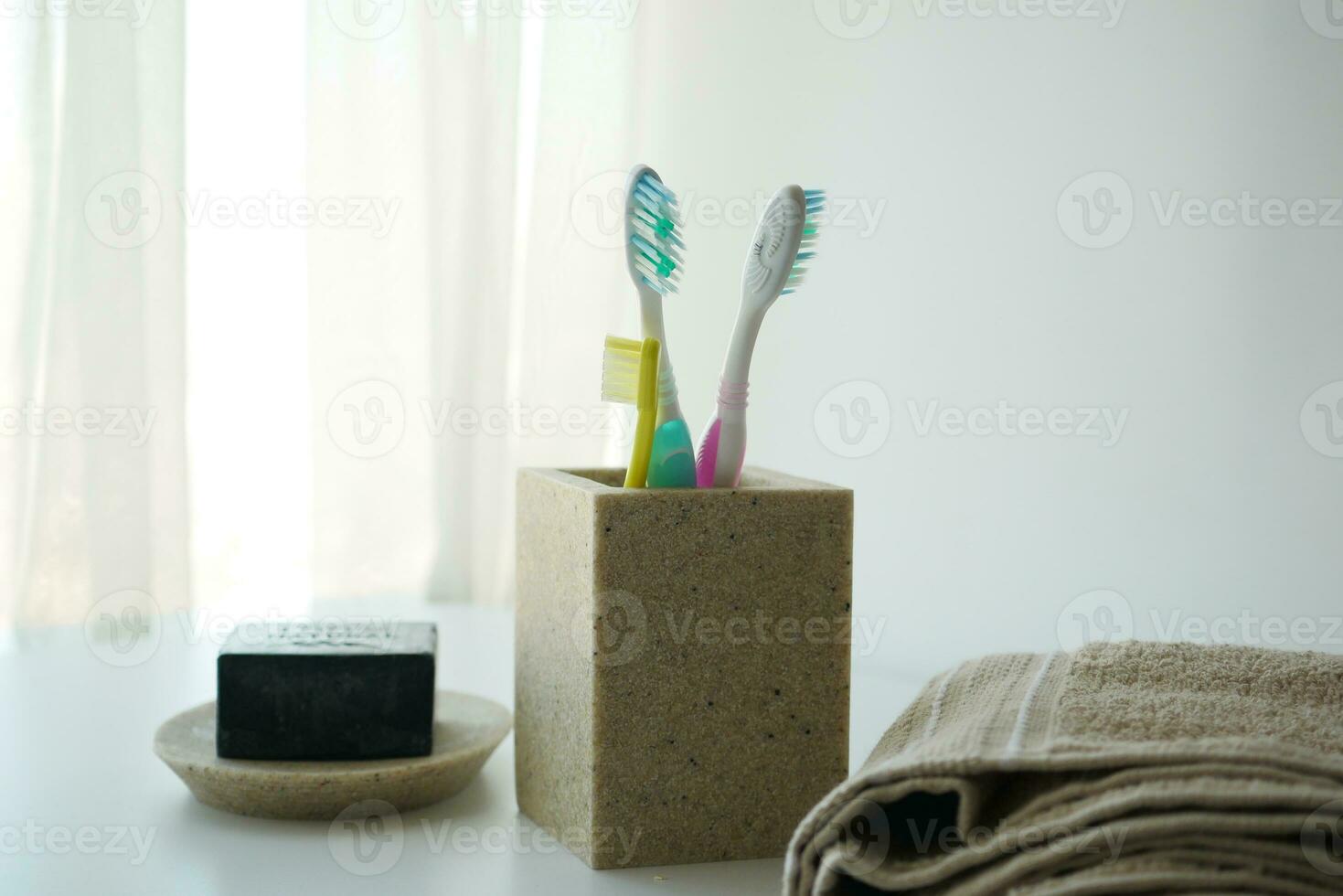 escovas de dentes coloridas em caneca branca contra a parede foto