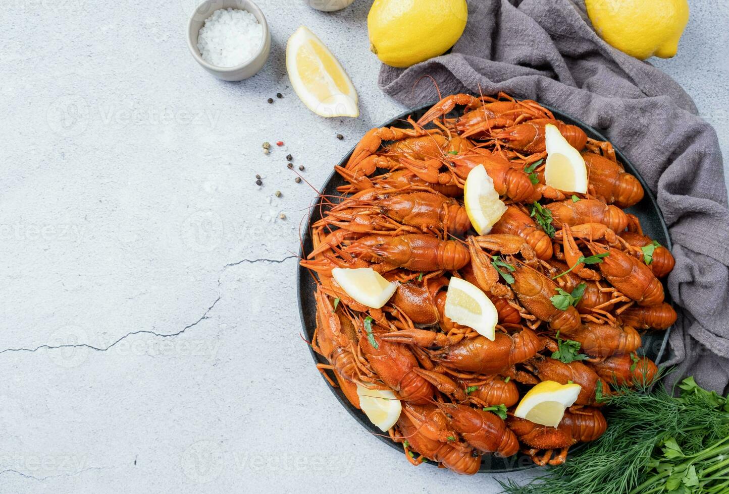 topo Visão do cozinhou lagosta prato com limões e especiarias em cimento fundo foto