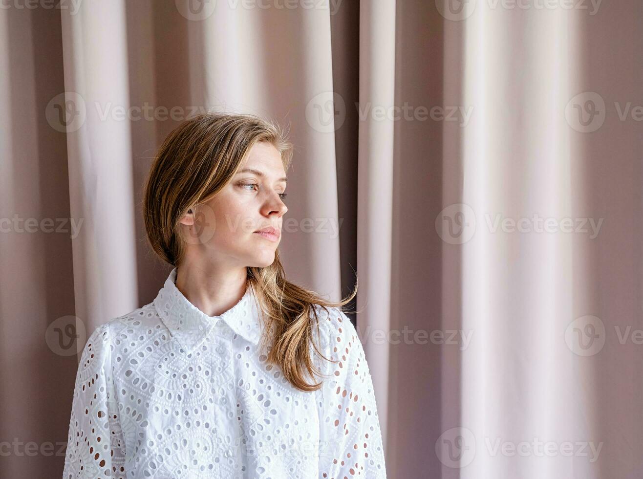 lindo mulher dentro moda vestir em pé em bege cortina fundo foto
