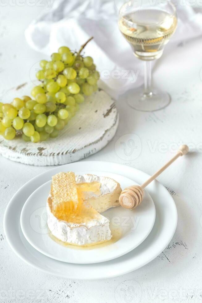 queijo Camembert com mel, uvas e branco vinho foto
