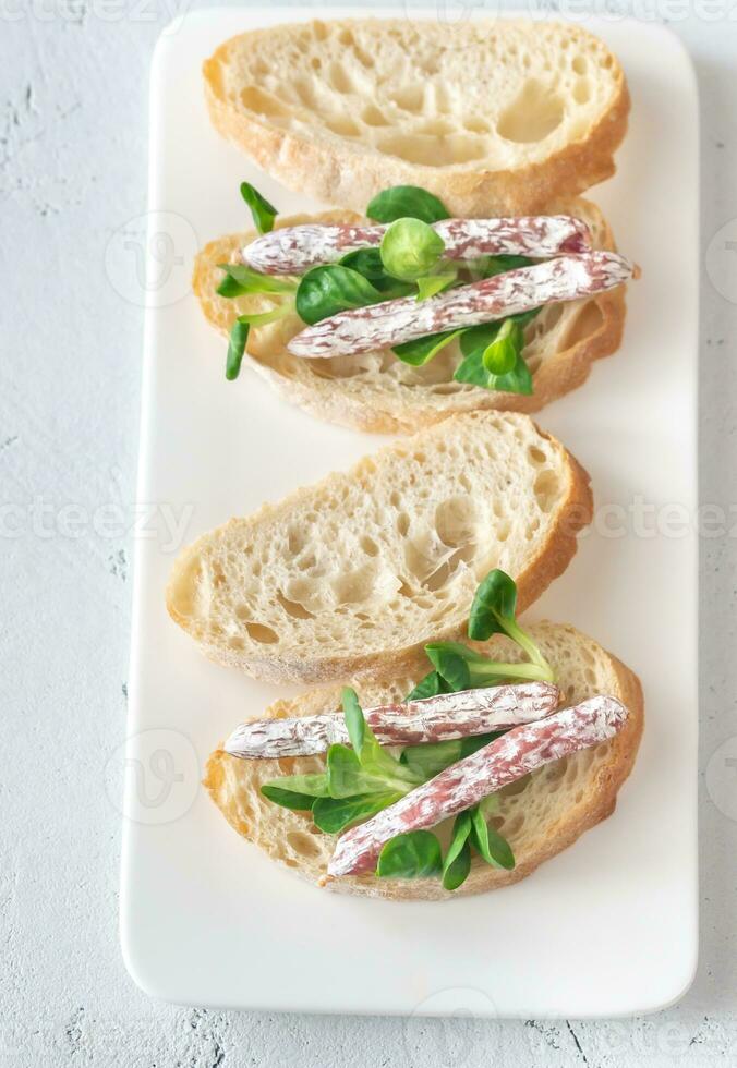 sanduíche com mini fuets no fundo branco foto