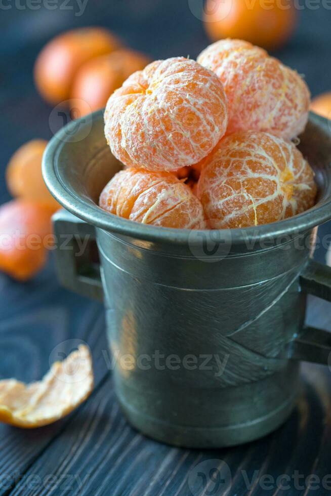 descascado tangerinas dentro a vintage copo foto