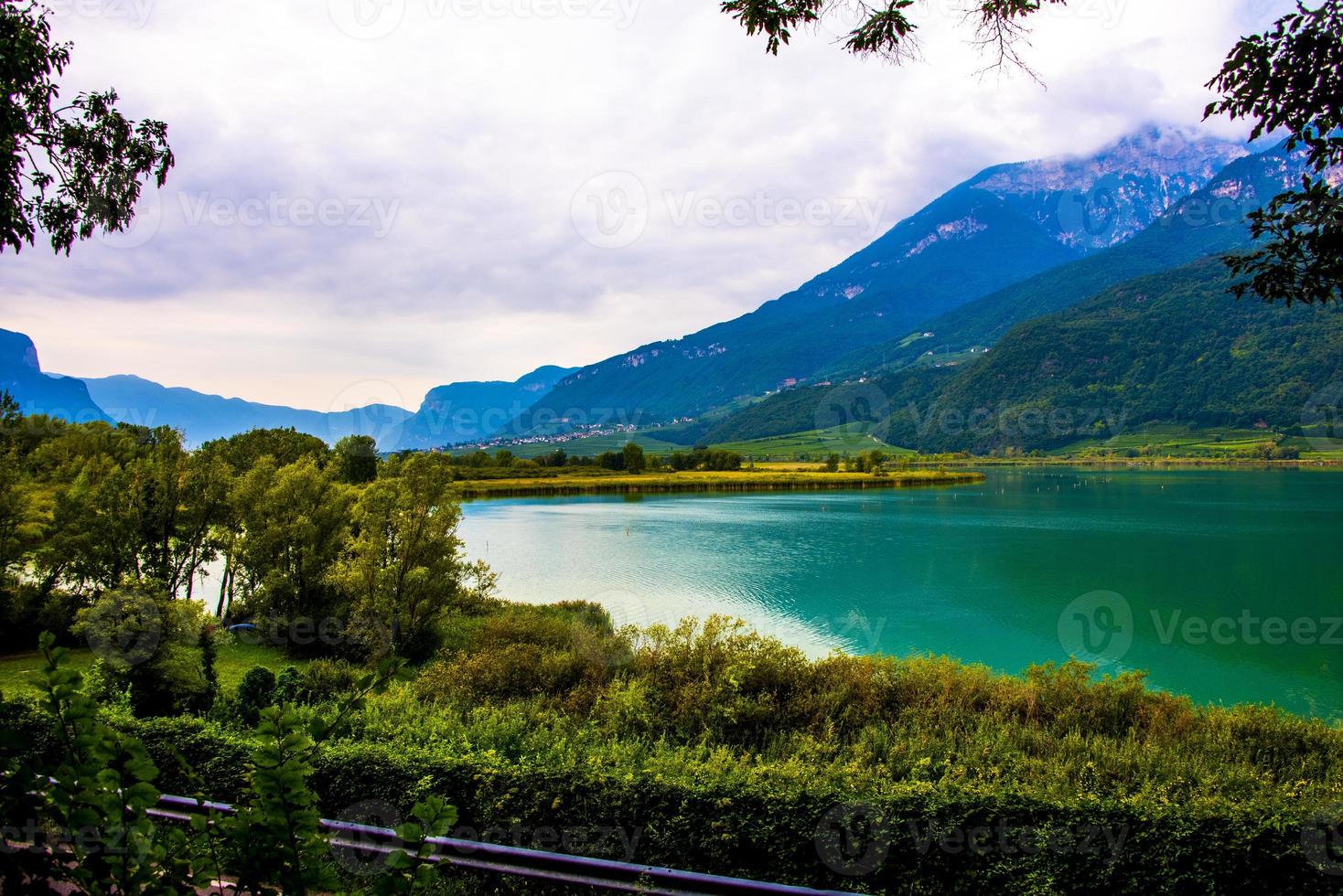 lago caldaro cercado pelas montanhas em bolzano, itália foto