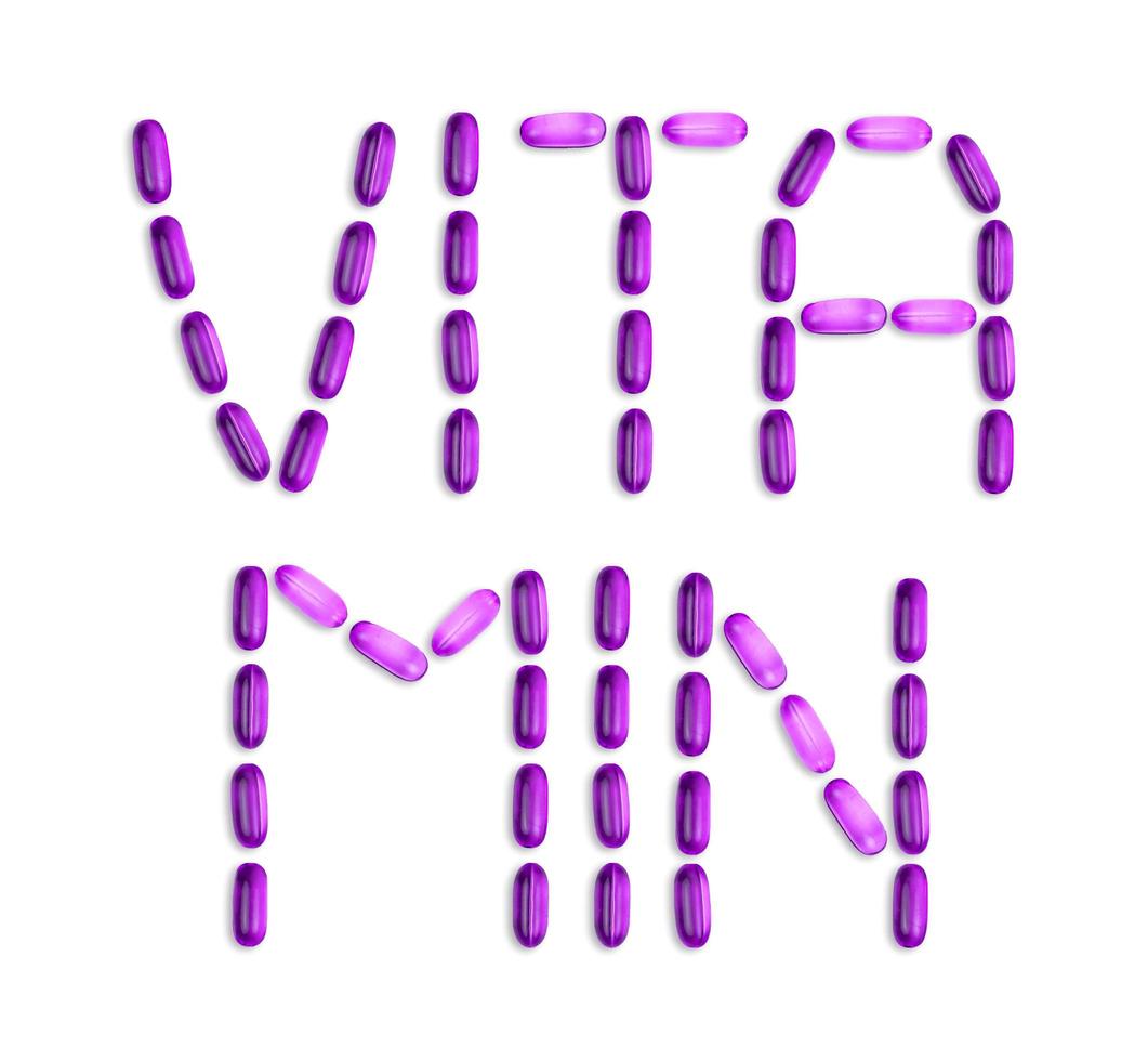 a palavra vitamina é apresentada com comprimidos em fundo branco foto