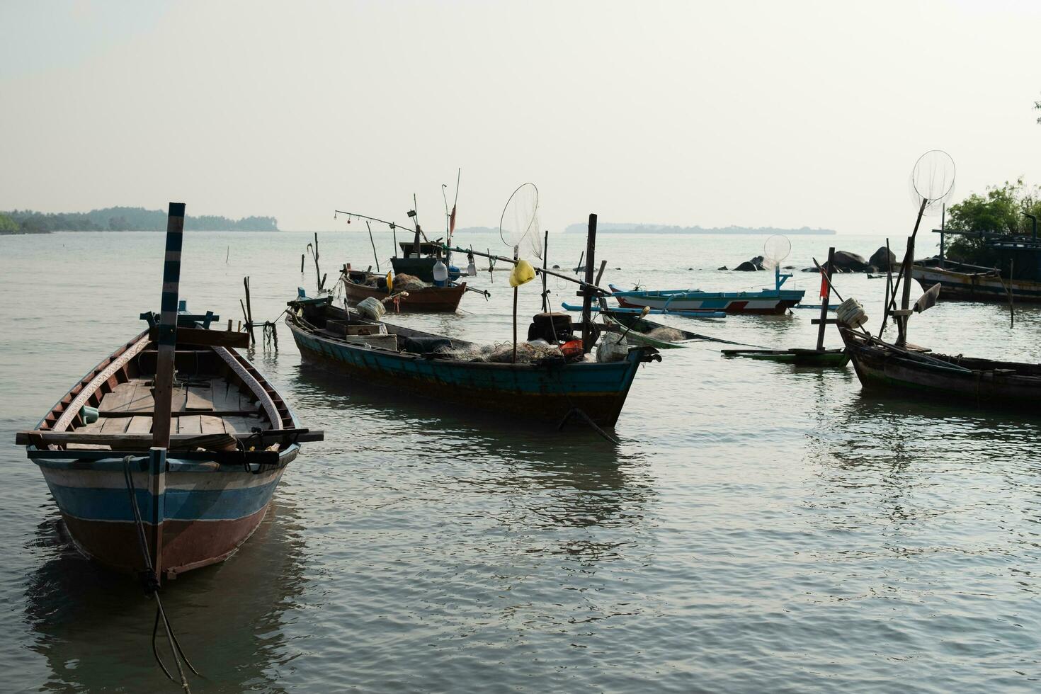 pescaria barcos em a de praia durante manhã névoa em a água foto