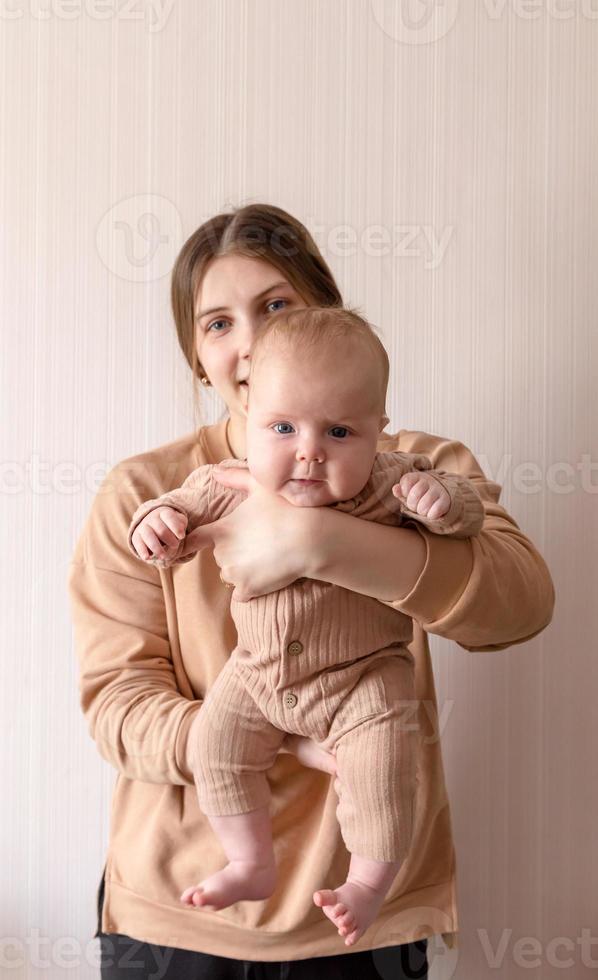 uma jovem mãe segura uma menina foto