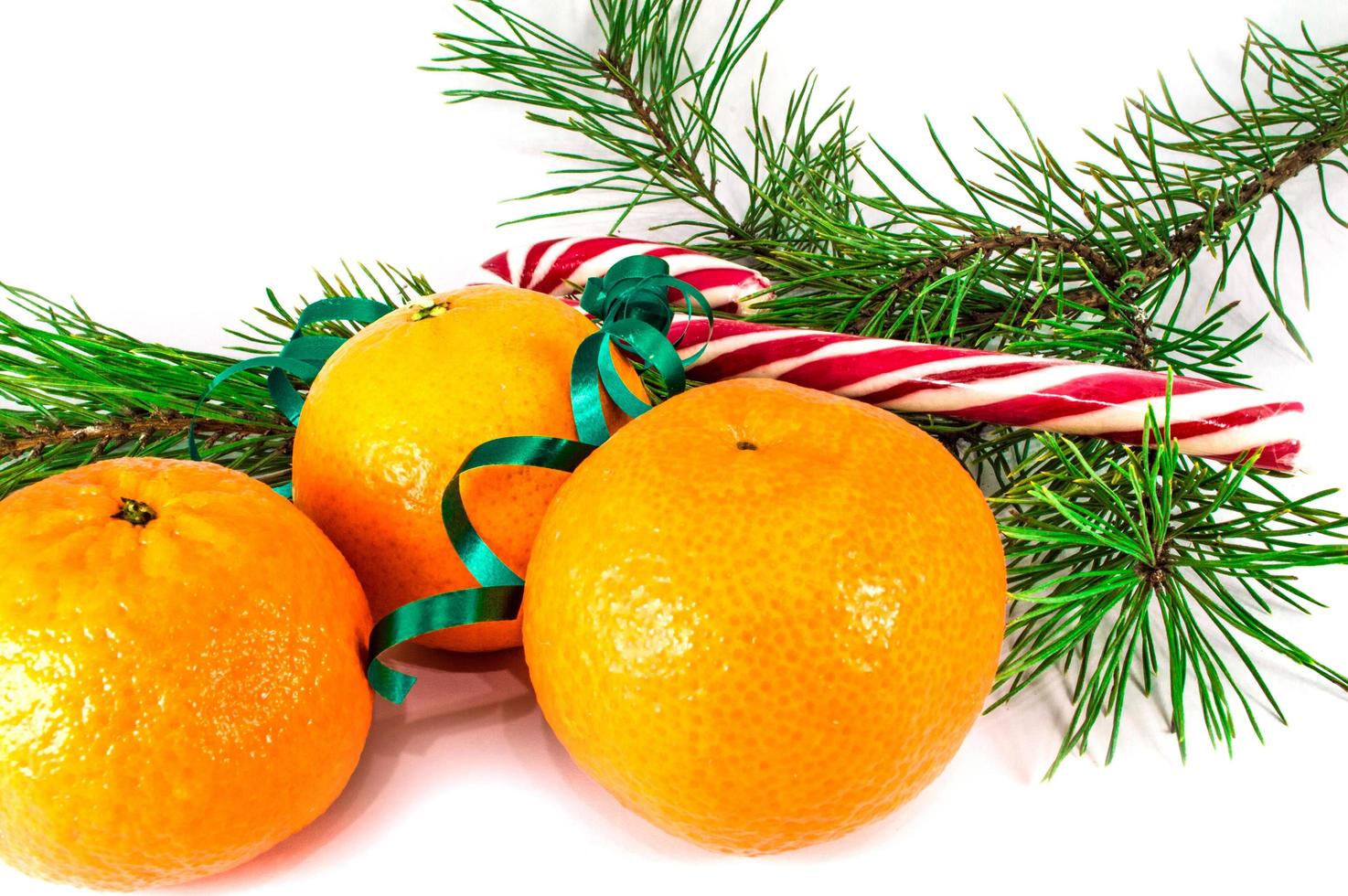 tangerinas laranja com enfeites de natal isoladas no fundo branco foto