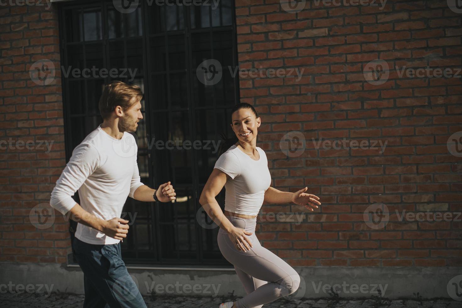 jovem casal correndo no ambiente urbano foto