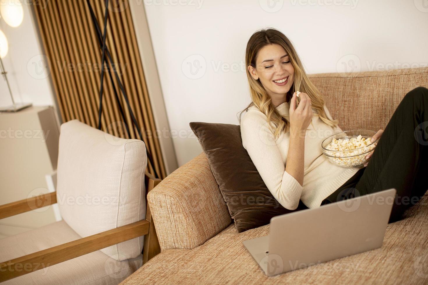 jovem mulher bonita usando um laptop em casa foto