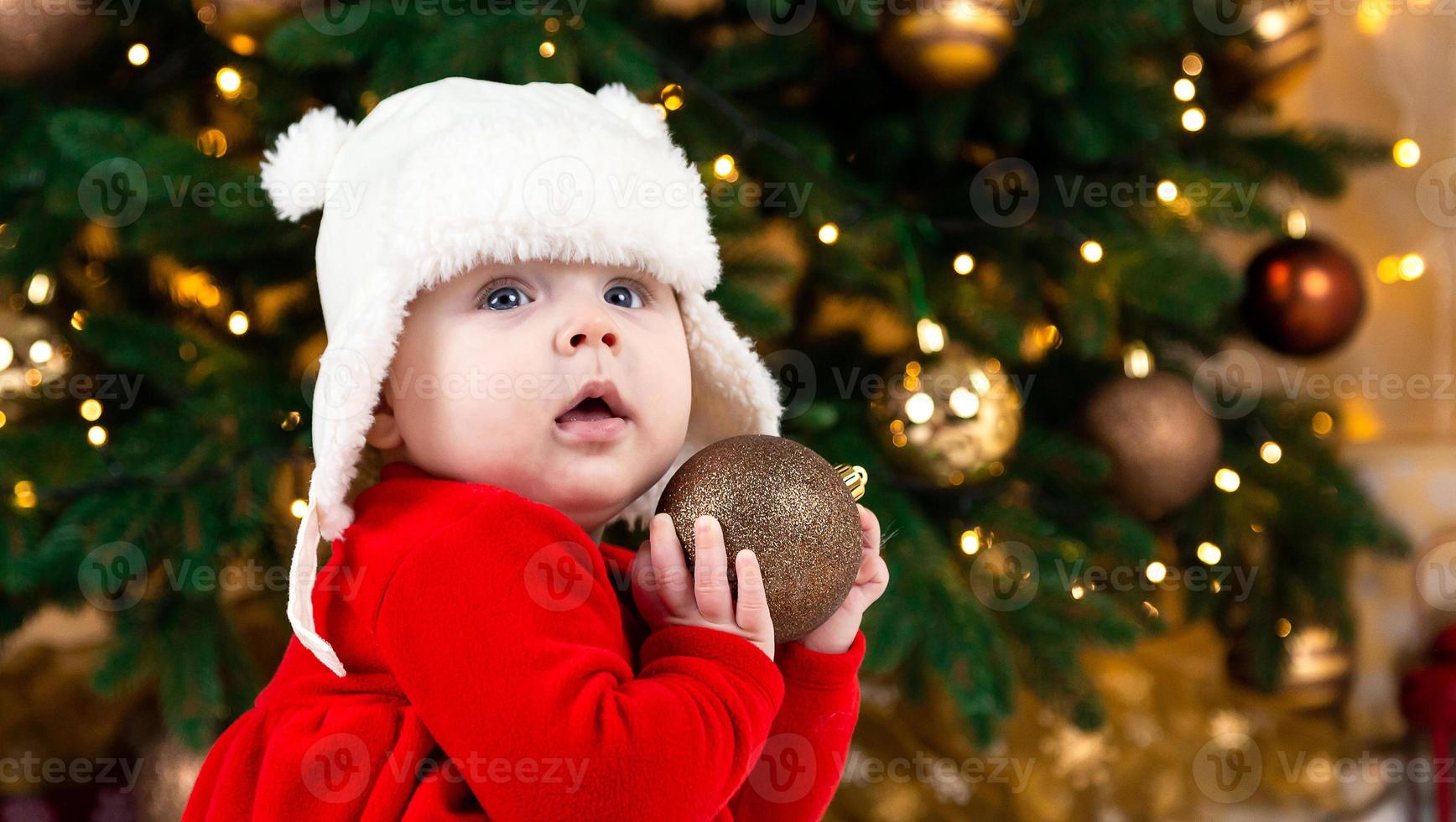 bebê segura uma bola de natal foto