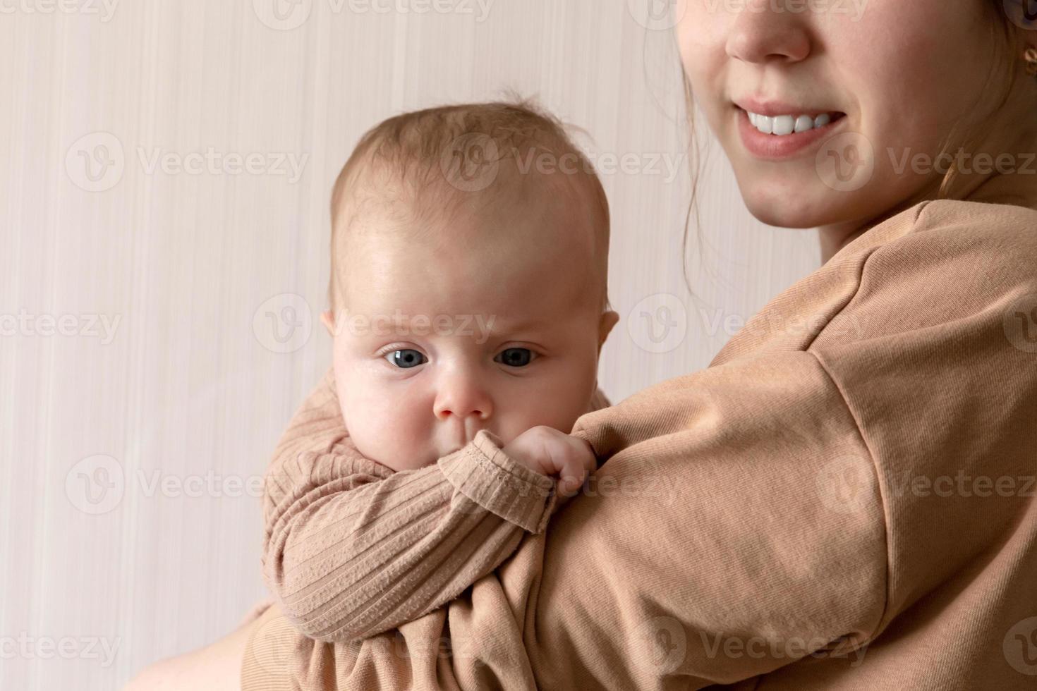 uma jovem mãe segura uma menina de 3 meses foto