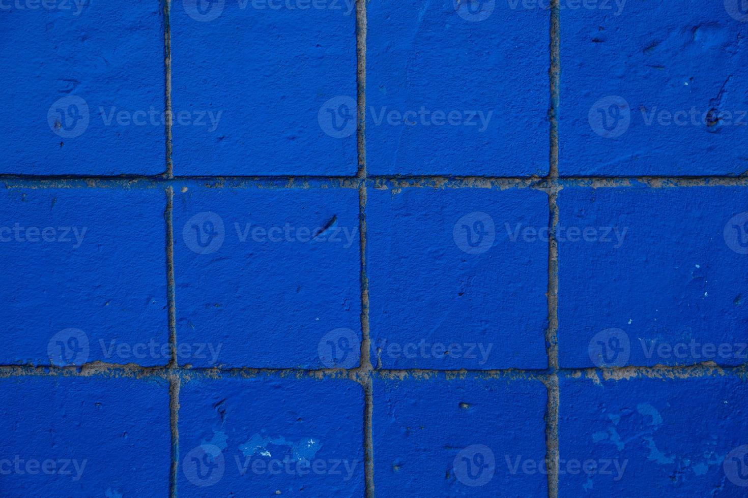 textura de fundo de parede de azulejos pequenos azulados desgastados e danificados foto