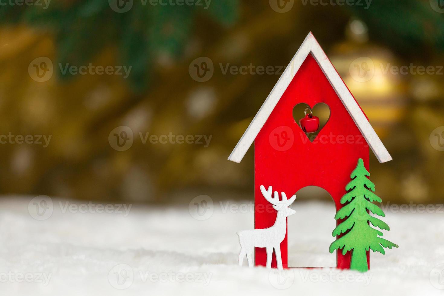 Natal brinquedo de madeira casa veado e árvore em um cobertor branco imitando neve foto