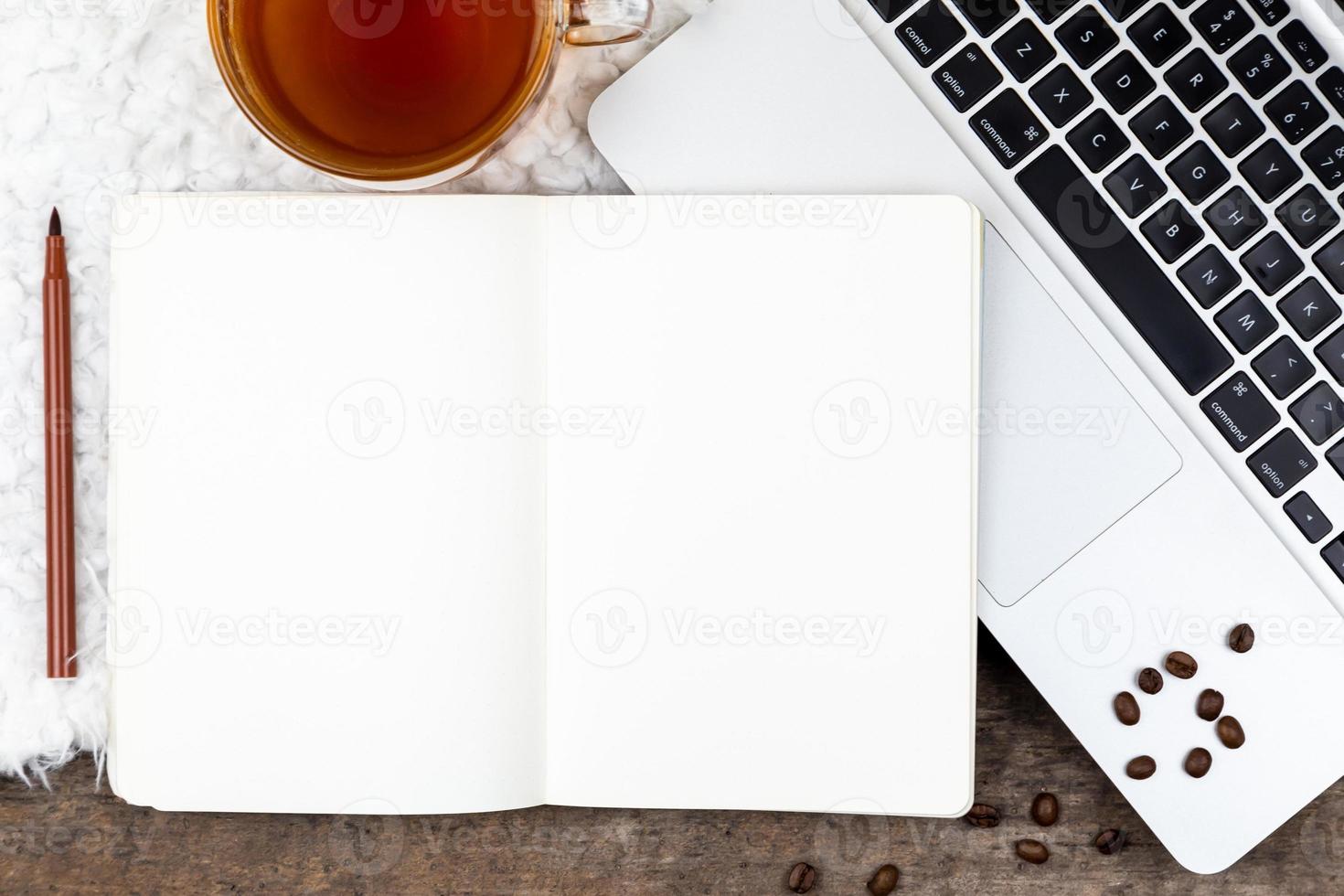 área de trabalho da mesa do escritório em casa com laptop e xícara de chá no fundo branco foto