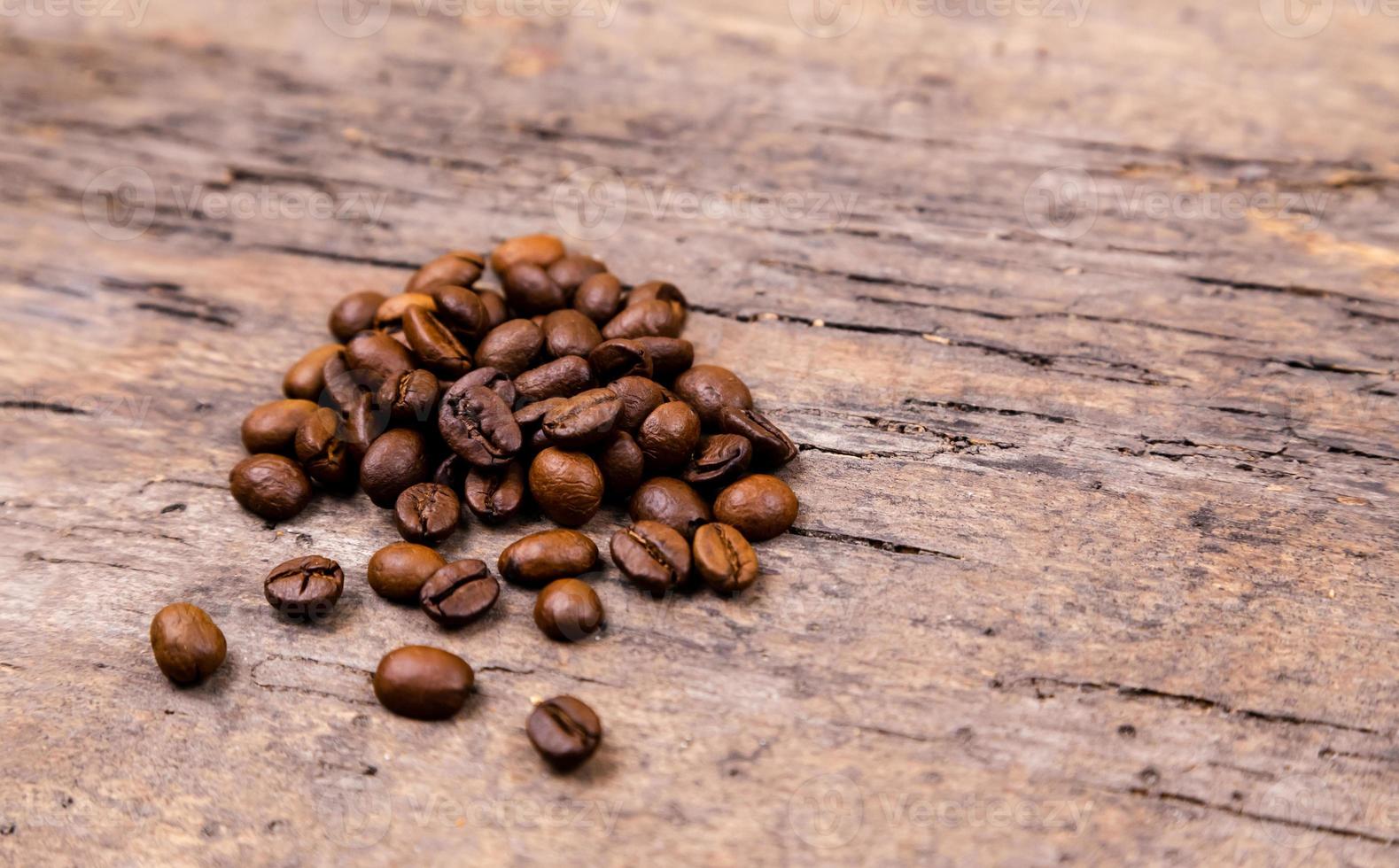 grãos de café aromáticos na mesa de madeira branca foto